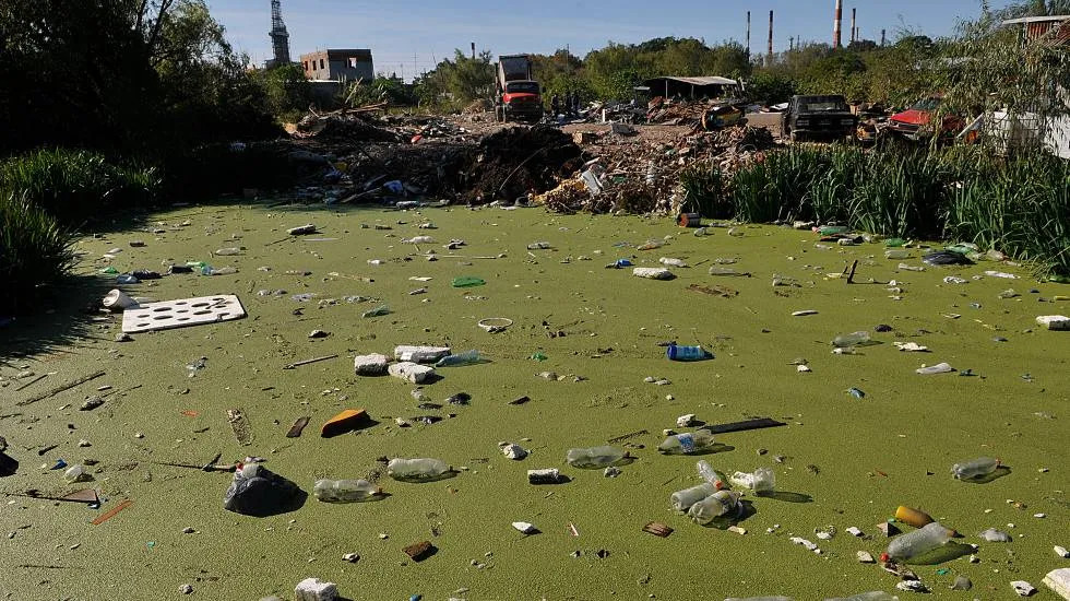 A river contaminated with chemicals and trash from the local refineries.